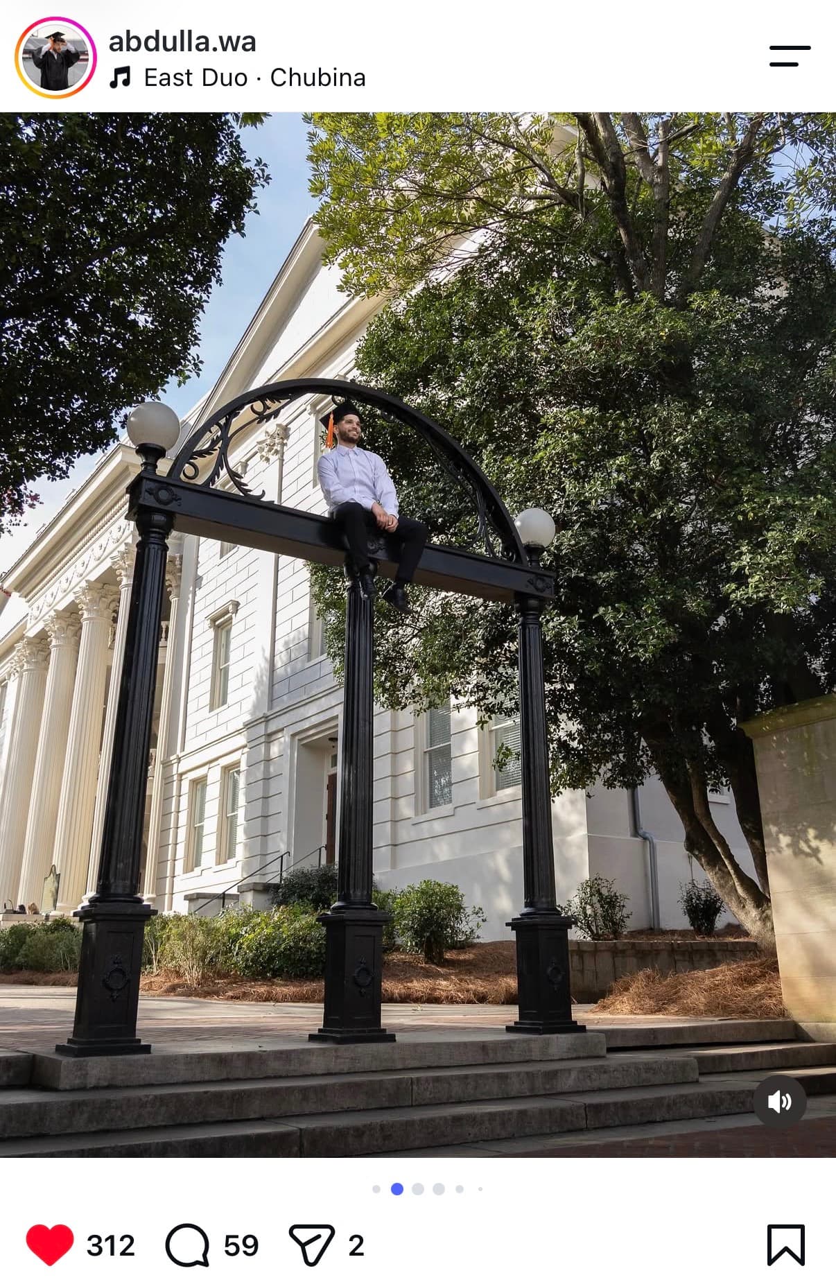 Instagram post: graduate in cap and tassel sitting on top of the UGA Arch in Athens
